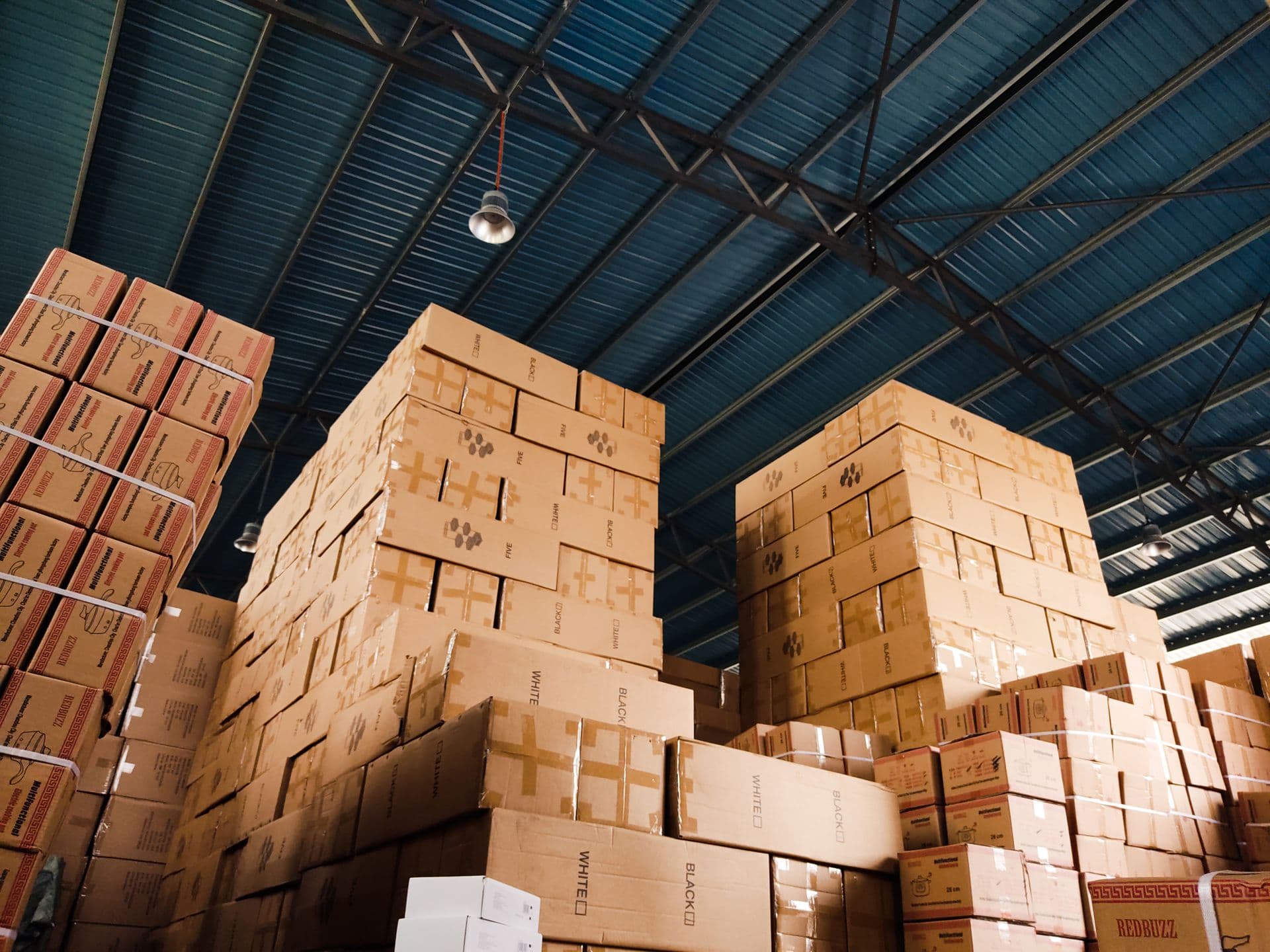 Pilas de cajas de cartón ordenadas en un almacén